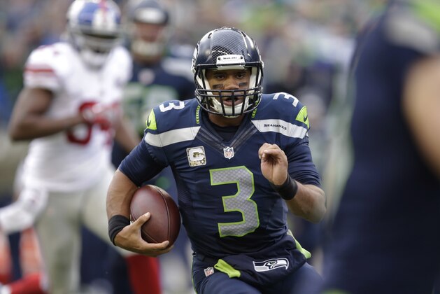 Seattle Seahawks quarterback Russell Wilson runs with the ball against the New York Giants in the first half of an NFL football game, Sunday, Nov. 9, 2014, in Seattle. (AP Photo/Scott Eklund)