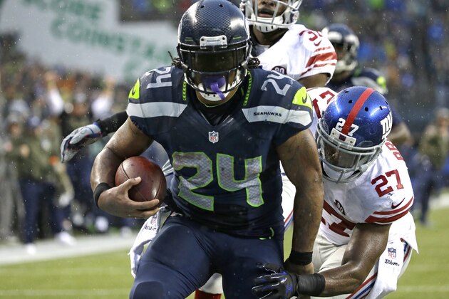 Seattle Seahawks running back Marshawn Lynch (24) scores his fourth touchdown of the NFL football game against the New York Giants, as Giants' Stevie Brown (27) attempts the tackle in the second half, Sunday, Nov. 9, 2014, in Seattle. (AP Photo/Elaine Thompson)