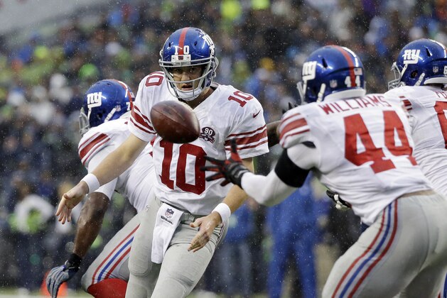 New York Giants quarterback Eli Manning (10) flips the ball to Andre Williams (44) during the second half against the Seattle Seahawks in an NFL football game, Sunday, Nov. 9, 2014, in Seattle. The Seahawks won 38-17. (AP Photo/Elaine Thompson)