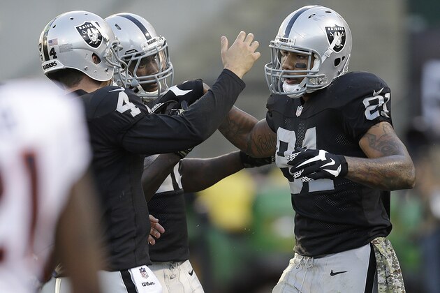 Oakland Raiders quarterback Derek Carr (4) celebrates with tight end Mychal Rivera (81) after they connected on an 18-yard touchdown pass during the fourth quarter of an NFL football game in Oakland, Calif., Sunday, Nov. 9, 2014. (AP Photo/Ben Margot)