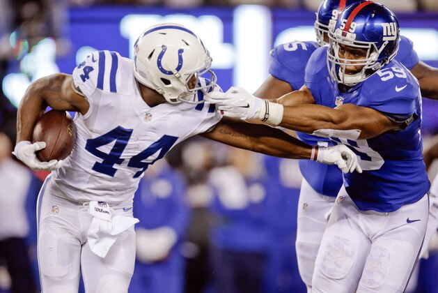New York Giants outside linebacker Devon Kennard (59) grabs the face mask of Indianapolis Colts' Ahmad Bradshaw (44) during the first half of an NFL football game Monday, Nov. 3, 2014, in East Rutherford, N.J. (AP Photo/Kathy Willens)