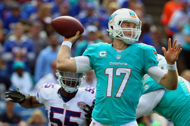 Miami Dolphins quarterback Ryan Tannehill (17) passes under pressure from Buffalo Bills defensive end Jerry Hughes (55) during the second half of an NFL football game on Sunday, Sept. 14, 2014, in Orchard Park, N.Y. (AP Photo/Bill Wippert)