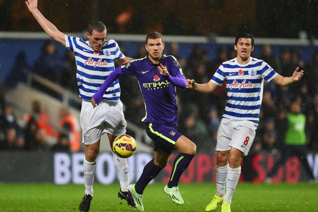 LONDON, ENGLAND - NOVEMBER 08:  Edin Dzeko of Manchester City evades Richard Dunne (L) and Joey Barton of QPR (R) during the Barclays Premier League match between Queens Park Rangers and Manchester City at Loftus Road on November 8, 2014 in London, England.  (Photo by Tom Dulat/Getty Images)