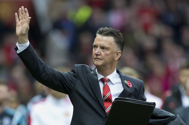FILE - In this Sunday, Oct. 26, 2014 file photo, Manchester United's manager Louis van Gaal wears a red poppy on his lapel as he waves before his team's English Premier League soccer match against Chelsea at Old Trafford Stadium, Manchester, England. A hundred years after the Great War began, the red flowers pinned to so many coat lapels in Britain, Canada and other Commonwealth countries every Armistice Day still evoke the vivid image of bright poppies springing up from destruction and decay in Belgium's Flanders Fields, one of WWI's bloodiest battlefields. (AP Photo/Jon Super, File)