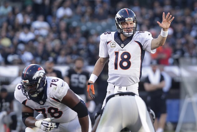 Denver Broncos quarterback Peyton Manning (18) signals at the line of scrimmage behind offensive tackle Ryan Clady (78) against the Oakland Raiders during the third quarter of an NFL football game in Oakland, Calif., Sunday, Nov. 9, 2014. (AP Photo/Marcio Jose Sanchez)