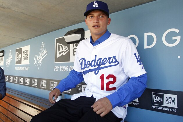 Los Angeles Dodgers infield prospect Corey Seager sits in the dugout prior to the team playing against the New York Mets in their baseball game in Los Angeles, Saturday, June 30, 2012. Corey Seager, selected 18th overall in the baseball draft, agreed to forgo a scholarship to South Carolina to sign a contract with a $2.35 million signing bonus Friday. (AP Photo/Alex Gallardo)