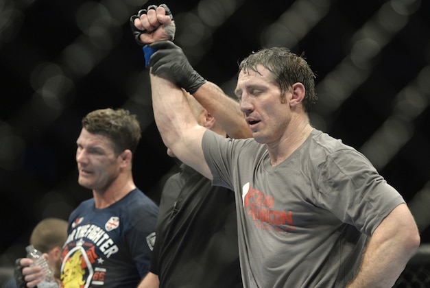 Apr 16, 2014; Quebec City, Quebec, Canada; Tim Kennedy (blue gloves) is declared the winner in his fight against Michael Bisping (red gloves) after their middleweight bout at Colisee Pepsi. Mandatory Credit: Eric Bolte-USA TODAY Sports