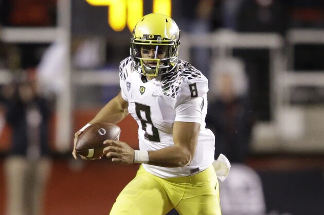 Oregon quarterback Marcus Mariota (8) carries the ball in the second half during an NCAA college football game against Utah Saturday, Nov. 8, 2014, in Salt Lake City. Oregon  won 51-27. (AP Photo/Rick Bowmer)