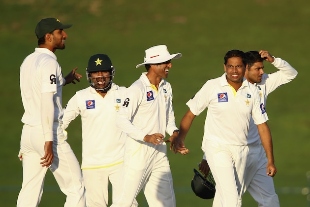 ABU DHABI, UNITED ARAB EMIRATES - NOVEMBER 11:  Zulifqar Babar of Pakistan celebrates with teammates after dismissing BJ Waitling of New Zealand  during Day Three of the First Test between Pakistan and New Zealand at Sheikh Zayed stadium on November 11, 2014 in Abu Dhabi, United Arab Emirates.  (Photo by Francois Nel/Getty Images)