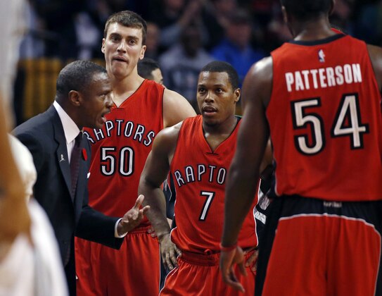 Toronto Raptors coach Dwane Casey, left, speaks to his players during a timeout in the first quarter of an NBA basketball game against the Boston Celtics in Boston, Wednesday, Nov. 5, 2014. (AP Photo/Elise Amendola)