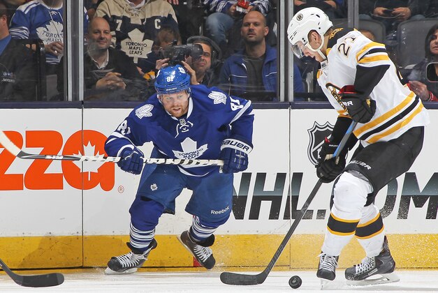 TORONTO, ON - OCTOBER 25:  Dougie Hamilton #27 of the Boston Bruins tries to control a puck in front of Phil Kessel #81 of the Toronto Maple Leafs during an NHL game at the Air Canada Centre on October 25, 2014 in Toronto, Ontario, Canada. The Bruins defeated the Maple Leafs 4-1. (Photo by Claus Andersen/Getty Images)