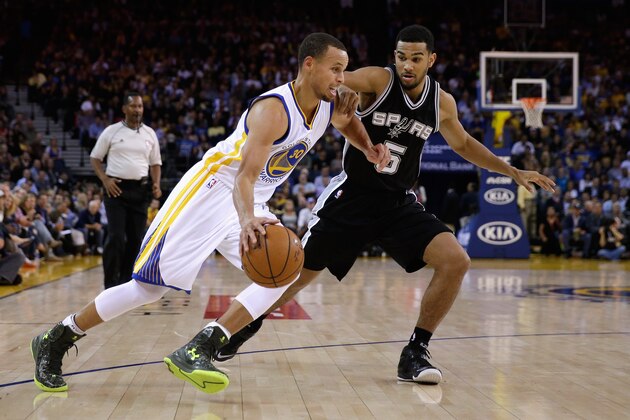 OAKLAND, CA - NOVEMBER 11:  Stephen Curry #30 of the Golden State Warriors drives on Cory Joseph #5 of the San Antonio Spurs at ORACLE Arena on November 11, 2014 in Oakland, California. NOTE TO USER: User expressly acknowledges and agrees that, by downloading and or using this photograph, User is consenting to the terms and conditions of the Getty Images License Agreement.  (Photo by Ezra Shaw/Getty Images)
