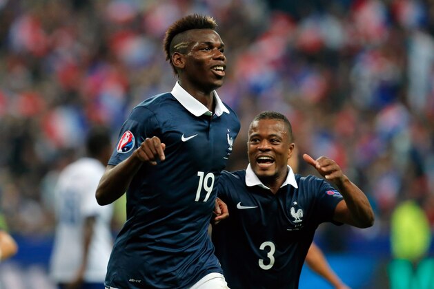 France's Paul Pogba, left, celebrates after scoring with his teammate Patrice Evra, during their international friendly soccer match against Portugal, at the Stade de France, in Saint Denis, north of Paris, France, Saturday, Oct. 11, 2014. (AP Photo/Thibault Camus)