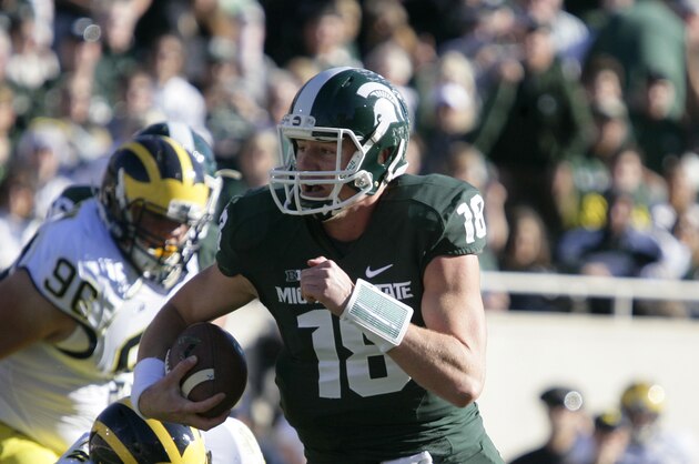 Michigan State quarterback Connor Cook (18) runs on a keeper against Michigan's Joe Bolden (35) during the first quarter of an NCAA college football game, Saturday, Oct. 25, 2014, in East Lansing, Mich. Michigan State won 35-11. (AP Photo/Al Goldis)