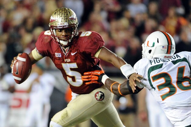 Nov 2, 2013; Tallahassee, FL, USA; Florida State Seminoles quarterback Jameis Winston (5) evades Miami Hurricanes linebacker Alex Figueroa (36) during the second half at Doak Campbell Stadium. Mandatory Credit: Melina Vastola-USA TODAY Sports
