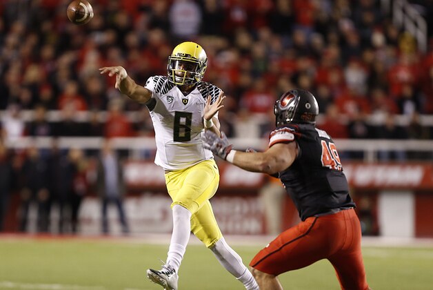 SALT LAKE CITY, UT - NOVEMBER 8:  Quarterback Marcus Mariota #8 of the Oregon Ducks throws a pass  as defensive end Hunter Dimick #49 of the Utah Utes  defends during the second half of an NCAA football game November 8, 2014 at Rice-Eccles Stadium in Salt Lake City, Utah. Oregon defeated Utah 51-27. (Photo by George Frey/Getty Images)