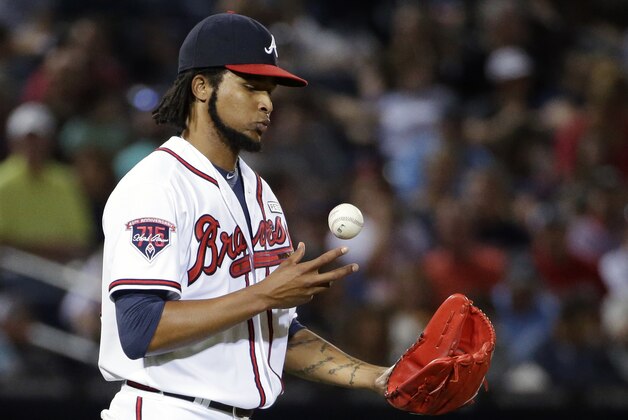 Atlanta Braves starting pitcher Ervin Santana bobbles the ball while returning to the mound in the third inning of a baseball game against the Miami Marlins, Friday, Aug. 29, 2014, in Atlanta. (AP Photo/David Goldman)