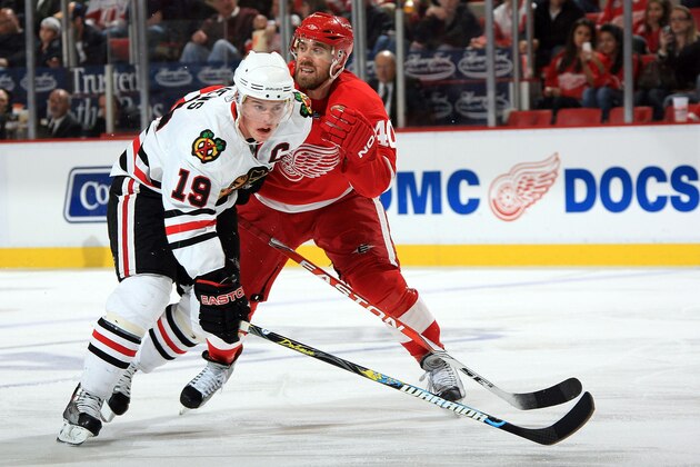 DETROIT - OCTOBER 08: Jonathan Toews #19 of the Chicago Blackhawks chases the puck as Henrik Zetterberg #40 of the Detroit Red Wings tries to tie him up during a NHL game at Joe Louis Arena on October 8, 2009 in Detroit, Michigan.  (Photo by Dave Reginek/NHLI via Getty Images)