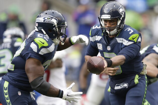 Seattle Seahawks quarterback Russell Wilson (3) hands off the football to running back Robert Turbin (22) against New York Giants in the first half of an NFL football game, Sunday, Nov. 9, 2014, in Seattle. (AP Photo/Scott Eklund)