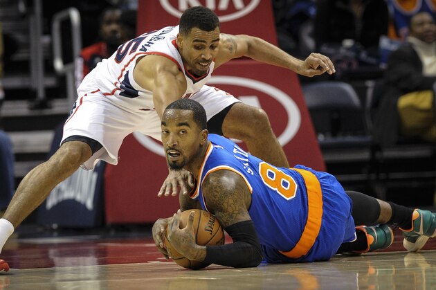 New York Knicks guard J.R. Smith (8) tries to keep a loose ball from Atlanta Hawks guard Thabo Sefolosha, of Switzerland, during the first half of an NBA basketball game, Saturday, Nov. 8, 2014, in Atlanta. (AP Photo/John Amis)
