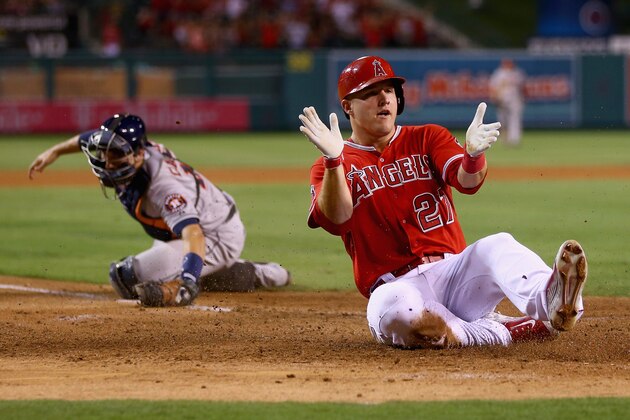 ANAHEIM, CA - SEPTEMBER 12:  Mike Trout #27 of the Los Angeles Angels of Anaheim slides safely past catcher Jason Castro #15 of the Houston Astros and scores a run on a catching error by shortstop Jonathan Villar (not pictured) in the fourth inning at Angel Stadium of Anaheim on September 12, 2014 in Anaheim, California.  (Photo by Jeff Gross/Getty Images)
