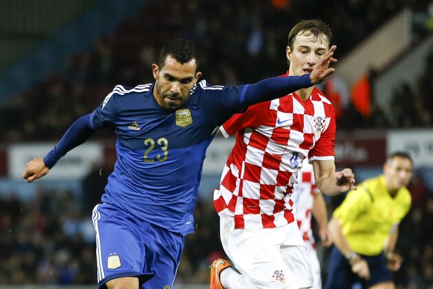 Argentina's Carlos Tevez has a shot on goal past Croatia's Marko Leskovic during the international friendly soccer match between Argentina and Croatia at the Boleyn Ground in London, Wednesday, Nov. 12, 2014. (AP Photo/Kirsty Wigglesworth)