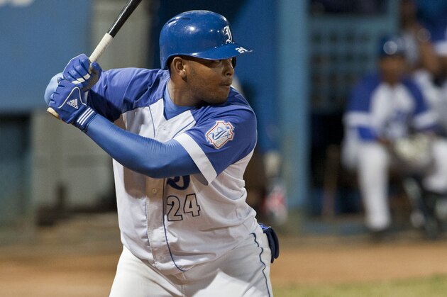 In this March 17, 2014 photo, Yasmani Tomas, of the Industriales, hits a single off Santiago de Cuba during the National Baseball Series in Havana, Cuba. Cuban authorities said Friday, June 20, 2014 that Tomas has defected. News of Tomas' defection came in a single paragraph at the end of an article in Communist Party newspaper Granma, which interviewed national baseball director Higinil Velez Carrion about two games next month against a visiting U.S. collegian team. (AP Photo/Franklin Reyes)