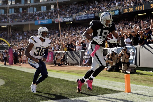OAKLAND, CA - OCTOBER 12:  Andre Holmes #18 of the Oakland Raiders catches a touchdown pass while covered by Marcus Gilchrist #38 of the San Diego Chargers at O.co Coliseum on October 12, 2014 in Oakland, California.  (Photo by Ezra Shaw/Getty Images)