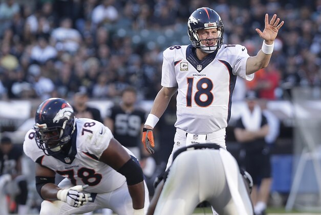 Denver Broncos quarterback Peyton Manning (18) signals at the line of scrimmage behind offensive tackle Ryan Clady (78) against the Oakland Raiders during the third quarter of an NFL football game in Oakland, Calif., Sunday, Nov. 9, 2014. (AP Photo/Marcio Jose Sanchez)