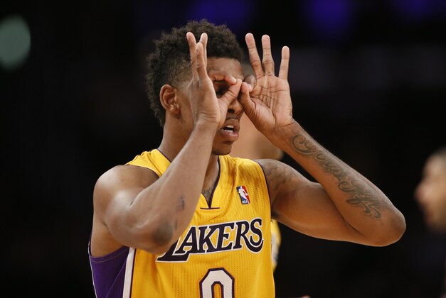 Los Angeles Lakers forward Nick Young puts his fingers around his eyes as he celebrates a three-pointer against the Portland Trail Blazers during the second half of an NBA basketball game in Los Angeles, Tuesday, April 1, 2014. (AP Photo/Danny Moloshok)