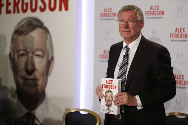 Former Manchester United manager Sir Alex Ferguson poses with his book 'My Autobiography' during a press conference in central London, Tuesday, Oct. 22, 2013. (AP Photo/Sang Tan)