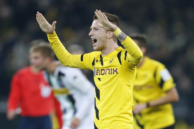 Dortmund's Marco Reus celebrates after Moenchengladbach's Christoph Kramer, left, scored an own goal during the German first division Bundesliga soccer match between BvB Borussia Dortmund and VfL Borussia Moenchengladbach in Dortmund, Germany, Sunday, Nov. 9, 2014. (AP Photo/Frank Augstein)