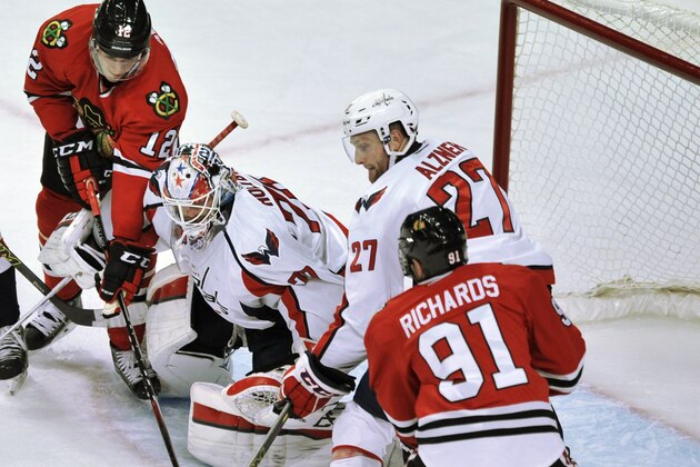 Washington Capitals goalie Braden Holtby (70) and teammate Karl Alzner (27) compete with Chicago Blackhawks' Brad Richards (91) and Peter Regin (12) for a loose puck during the second period of an NHL hockey game in Chicago, Friday, Nov. 7, 2014. Washington won 3-2. (AP Photo/Paul Beaty)