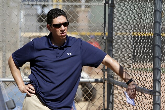 Texas Rangers President of Baseball Operations and General Manager, Jon Daniels, watches as pitcher Yu Darvish throws in an intrasquad game during spring training baseball practice, Monday Feb. 24, 2014, in Surprise, Ariz. (AP Photo/Tony Gutierrez)