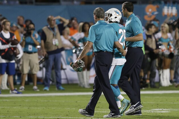 Miami Dolphins strong safety Will Davis is helped off the field after a play during the second half of an NFL football game against the Buffalo Bills, Thursday, Nov. 13, 2014 in Miami Gardens, Fla. (AP Photo/Alan Diaz)
