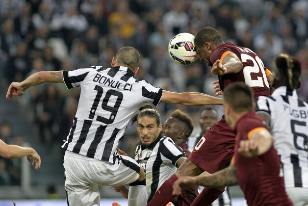 Roma' Seydou Keita, right, jumps for the ball with Juventus' Leonardo Bonucci during a Serie A soccer match between Juventus and Roma at the Juventus stadium, in Turin, Italy, Sunday, Oct. 5, 2014. (AP Photo/ Massimo Pinca)