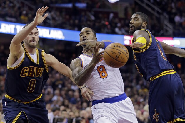 New York Knicks' J.R. Smith (8) loses the ball against Cleveland Cavaliers' Kevin Love (0) and Kyrie Irving in the second quarter of an NBA basketball game Thursday, Oct. 30, 2014, in Cleveland. (AP Photo/Tony Dejak)