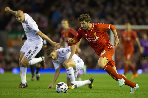 Liverpool's Fabio Borini, right, keeps the ball from Swansea's Angel Rangel, bottom centre, and Jonjo Shelvey during the English League Cup soccer match between Liverpool and Swansea at Anfield Stadium, Liverpool, England, Tuesday Oct. 28, 2014. (AP Photo/Jon Super)