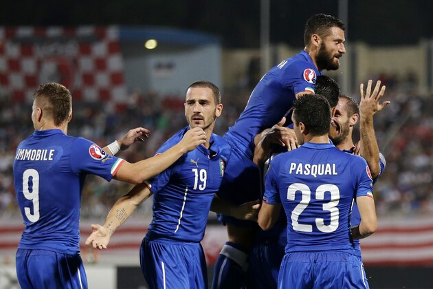 Italy’s Graziano Pelle, covered by his teammates, celebrates after scoring during the Euro 2016 qualifying soccer match between Malta and Italy, at the National Stadium Ta' Qali, in Valletta, Malta, Monday, Oct. 13, 2014. (AP Photo/Antonio Calanni)