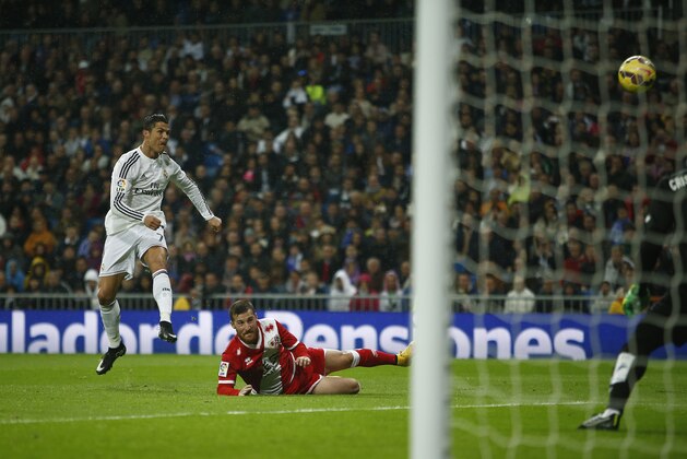 Real Madrid's Cristiano Ronaldo, left, attempts to shoot a goal in vain during a Spanish La Liga soccer match against Rayo Vallecano at the Santiago Bernabeu stadium in Madrid, Spain, Saturday, Nov. 8, 2014. (AP Photo/Andres Kudacki)