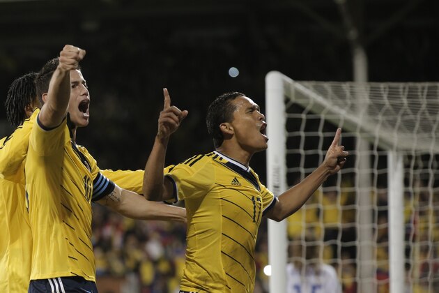 Colombia's captain James Rodriguez, left, celebrates with his teammate Carlos Bacca, right, after Bacca scored against USA, during an international friendly soccer match at the Craven Cottage ground in London, Friday, Nov. 14, 2014. Colombia won the match 2-1. (AP Photo/Lefteris Pitarakis)