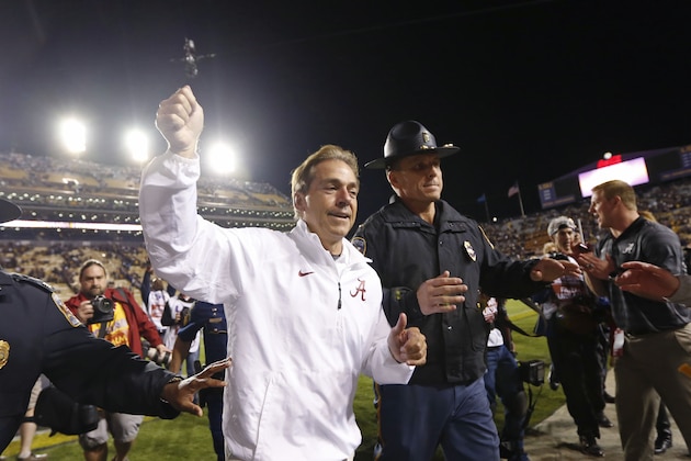 Alabama coach Nick Saban waves to fans as he runs off the field after Alabama defeated LSU 20-13 in overtime in an NCAA college football game in Baton Rouge, La., Saturday, Nov. 8, 2014.  (AP Photo/Jonathan Bachman)