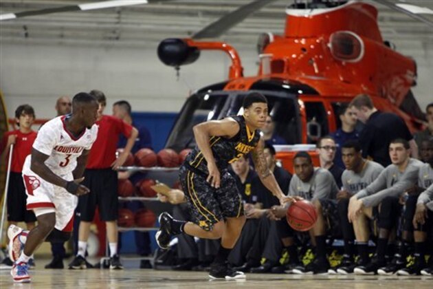 Minnesota’s Nate Mason, right, dribbles the ball as Louisville’s Chris Jones follows during a NCAA college basketball Armed Forces Classic game inside a hangar at the United States Coast Guard Air Station base in Aguadilla, Puerto Rico, Friday, Nov. 14, 2014. (AP Photo/Ricardo Arduengo)