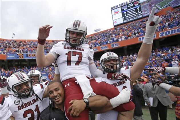 Members of the South Carolina football team carry quarterback Dylan Thompson (17) off the field after he scored the game-winning touchdown in overtime to defeat Florida 23-20 in an NCAA college football game in Gainesville, Fla., Saturday, Nov. 15, 2014. (AP Photo/John Raoux)