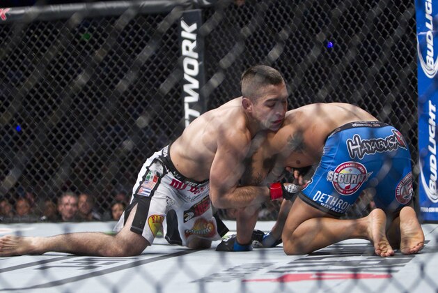 Ricardo Lamas, left, battles against Dennis Bermudez, both from the United States, during a UFC 180 mixed martial arts bout in Mexico City, Saturday, Nov. 15, 2014. Lamas won the fight. (AP Photo/Christian Palma)