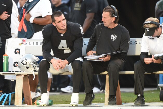 November 9, 2014; Oakland, CA, USA; Oakland Raiders quarterback Derek Carr (4) talks to offensive coordinator Greg Olson (right) during the fourth quarter against the Denver Broncos at O.co Coliseum. The Broncos defeated the Raiders 41-17. Mandatory Credit: Kyle Terada-USA TODAY Sports