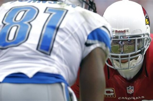 CORRECTS TO PATRICK PETERSON -Detroit Lions wide receiver Calvin Johnson is reflected in the face mask of Arizona Cardinals defensive back Patrick Peterson during the second half of a NFL football game, Sunday, Sept. 15, 2013, in Glendale, Ariz. (AP Photo/Darryl Webb)