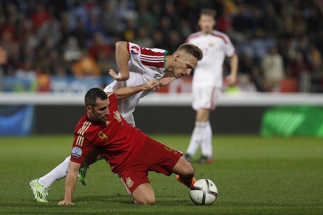 Spain's Paco Alcacer, button, and Belarus' Sergei Krivets, top, vie for the ball during the Euro 2016 qualifying match between Spain and Belarus at the Nuevo Colombino stadium, in Huelva, Spain, Saturday Nov. 15, 2014. (AP Photo/Miguel Angel Morenatti)