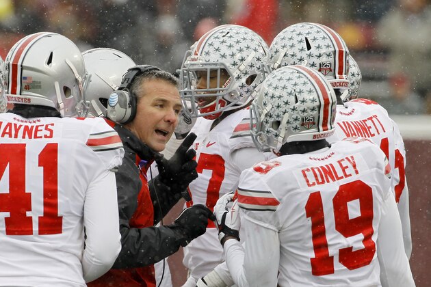 Ohio State head coach Urban Meyer talks with his players during the fourth quarter of an NCAA college football game against Minnesota in Minneapolis Saturday, Nov. 15, 2014. Ohio State won 31-24. (AP Photo/Ann Heisenfelt)