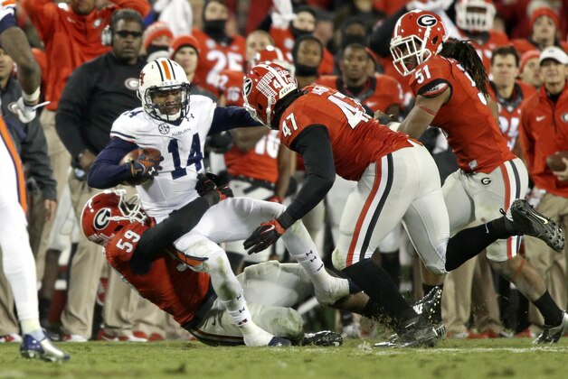 Nov 15, 2014; Athens, GA, USA; Auburn Tigers quarterback Nick Marshall (14) gets tackled by Georgia Bulldogs linebacker Jordan Jenkins (59) for a short gain as Bulldogs defensive end Ray Drew (47) and linebacker Ramik Wilson (51) pursue in the fourth quarter of their game at Sanford Stadium. Georgia won 34-7. Mandatory Credit: Jason Getz-USA TODAY Sports